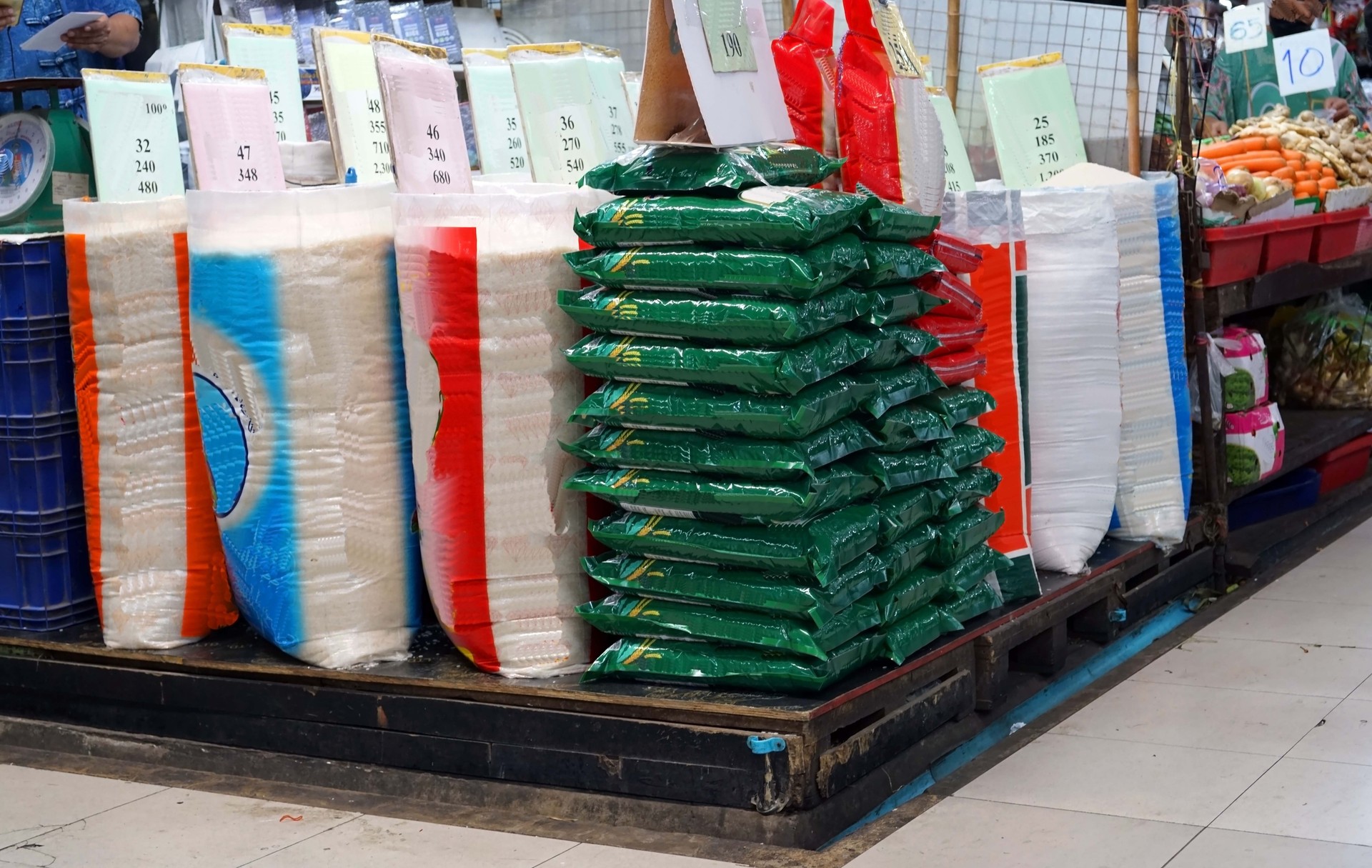 A pile of rice sacks for sale on the ground in the market to selling.